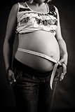 pregnant woman tenderly measuring her tummy