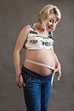 beautiful pregnant woman tenderly measuring her tummy
