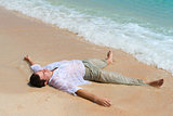 Tired man lie on sandy beach