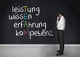 Elegant businessman looking at chalkboard with team anagram in german