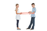 Cheerful brother and sister playing with hula hoop