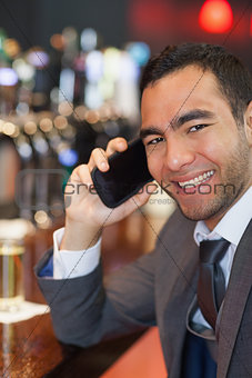 Happy businessman on the phone having a drink