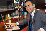 Smiling businessman working on his laptop