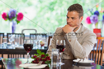 Handsome man waiting for his girlfriend at restaurant