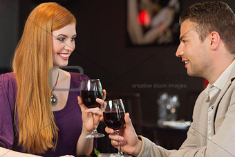 Handsome man having glass of wine with his gorgeous girlfriend