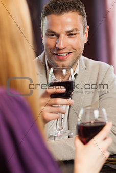 Happy man having glass of wine with his gorgeous girlfriend