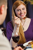 Pretty woman smiling at her husband during dinner