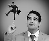 Thoughtful businessman showing shrunk colleague dancing on his finger