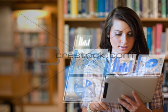 Pretty student working on her futuristic tablet
