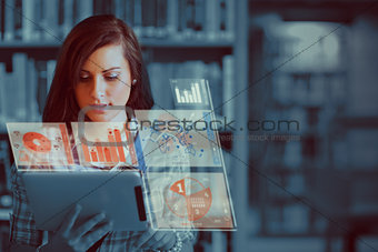 Pretty student working on her futuristic tablet computer