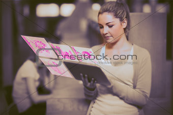 Pretty blonde student working on her futuristic tablet computer