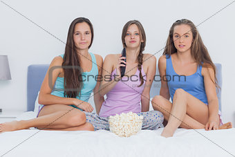 Girls sitting on bed at sleepover