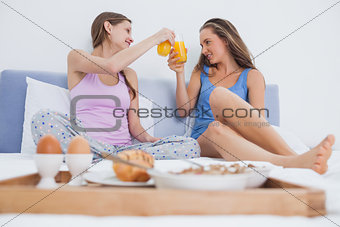 Friends enjoying breakfast in bed