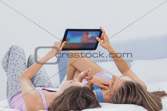 Friends wearing pajamas holding tablet