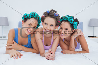 Girls in hair rollers lying in bed