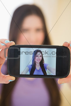 Pretty girl taking a photo of herself with her mobile phone