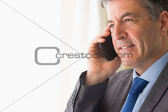 Thoughtful man calling someone with his mobile phone