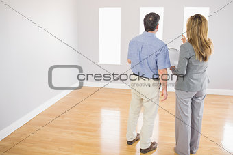 Blonde realtor showing a room to a potential buyer