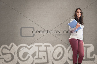 Cheerful student holding notebook posing