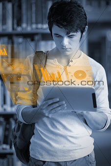 Concentrated handsome student working on his futuristic tablet