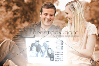 Happy young couple watching photos together on digital interface