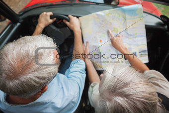 Overhead view of mature couple on holidays reading map