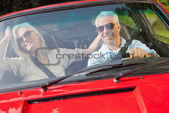 Happy mature couple in red cabriolet