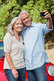 Smiling mature couple taking pictures of themselves