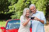 Cheerful mature couple looking at pictures on their camera