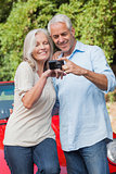 Smiling mature couple looking at pictures on their camera