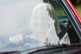 Cheerful mature woman on the phone driving red cabriolet