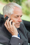 Serious businessman on the phone driving cabriolet