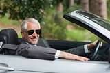 Smiling mature businessman driving classy cabriolet