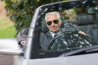 Cheerful mature businessman driving classy cabriolet