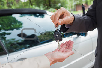 Close up on business man giving his keys to his partner
