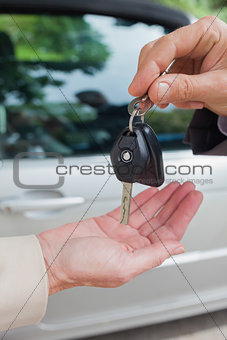 Close up on business man giving his keys to his female partner