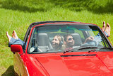 Smiling young couple relaxing in classy cabriolet