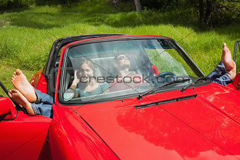 Cheerful young couple relaxing in classy cabriolet