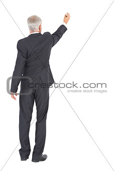 Rear view of serious businessman standing and writing