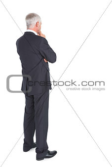 Thoughtful businessman standing back to camera