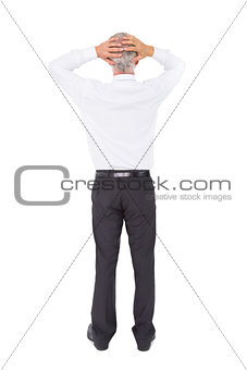 Businessman standing back to camera with hands on head