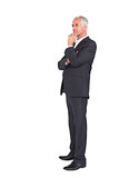 Mature thoughtful businessman crossing arms