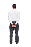 Rear view of young businessman wearing handcuffs