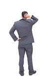 Young businessman standing back to camera scratching his head
