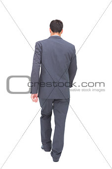 Young businessman walking away from camera