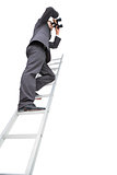 Low angle view of businessman standing on ladder using binoculars