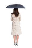Rear view of classy businesswoman holding umbrella