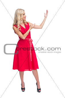 Glamorous blonde woman presenting something