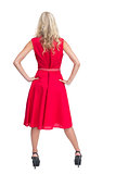 Rear view of gorgeous blonde in red dress posing