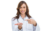 Smiling doctor pointing at something in her hand
